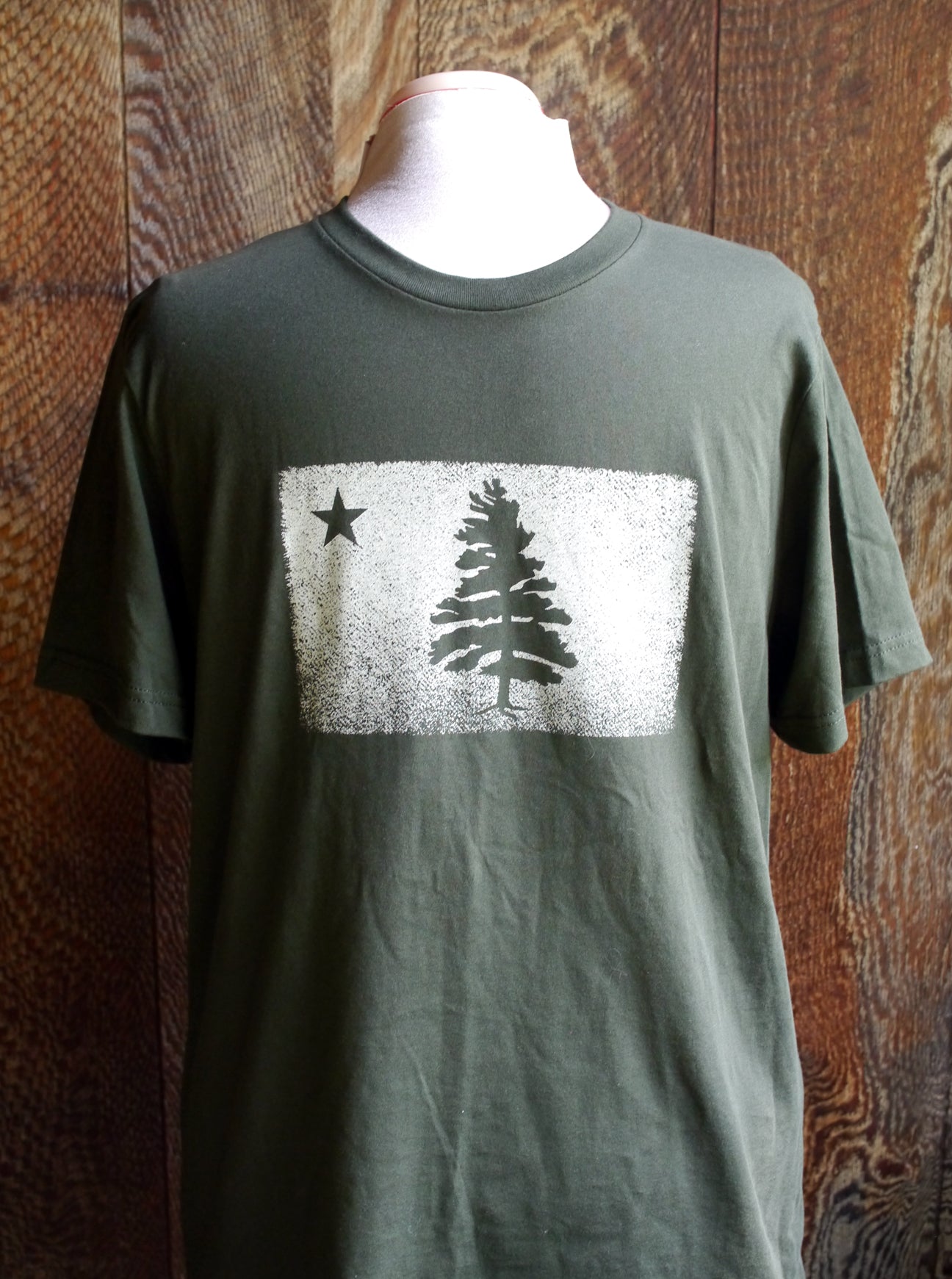 Super soft dark green short sleeve t-shirt with 1901 Original Maine Flag distressed logo screen printed on the chest